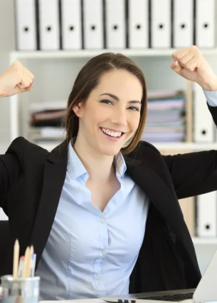 Smiling woman raising her fist in excitement, representing the boost in productivity and focus from in-office massages