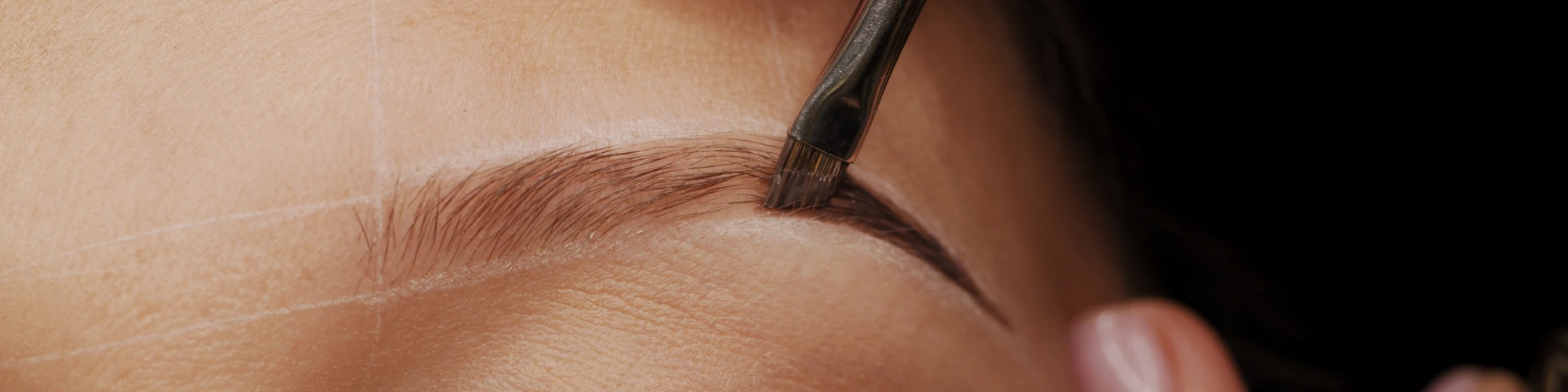 HD Brows shaping process with brush applying custom tint in Dubai.