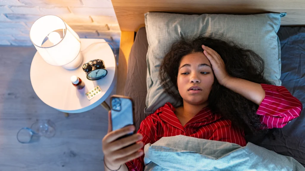 a woman lying in bed watching phone