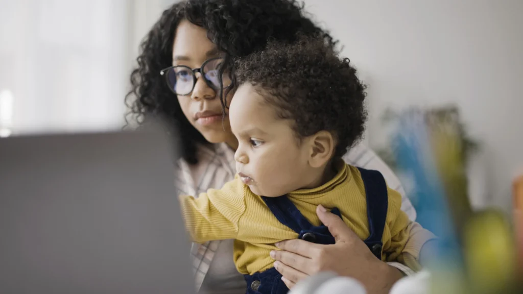 a woman holding a baby while working