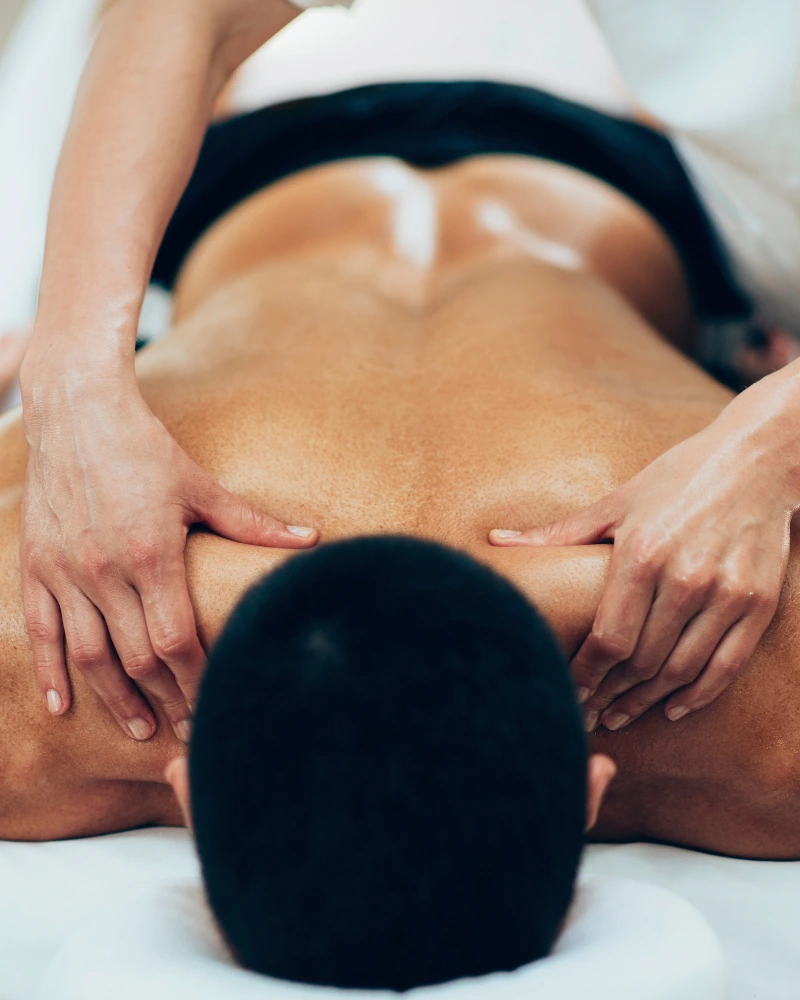 Sports massage therapist applying deep tissue techniques at home in Dubai