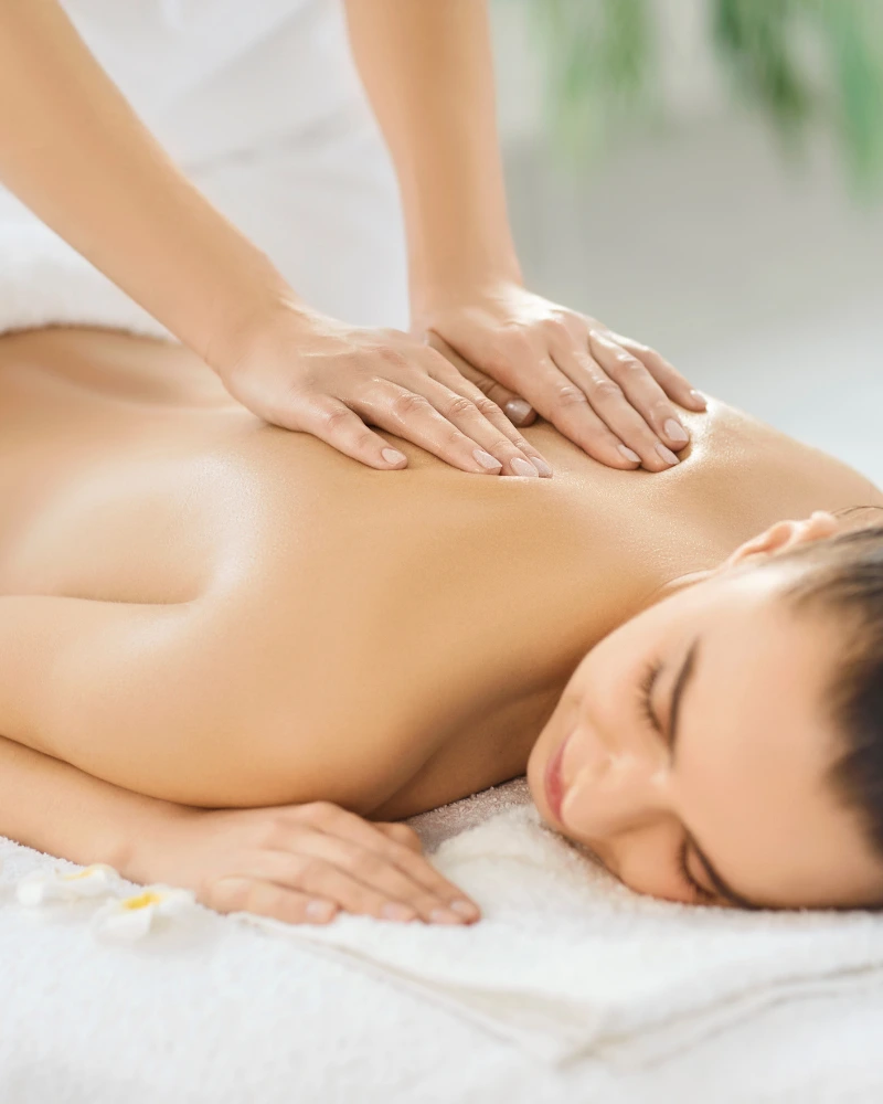 Therapist performing Swedish relaxation massage with long flowing effleurage strokes at home in Dubai